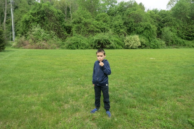 Damian blowing dandelions to start his hike